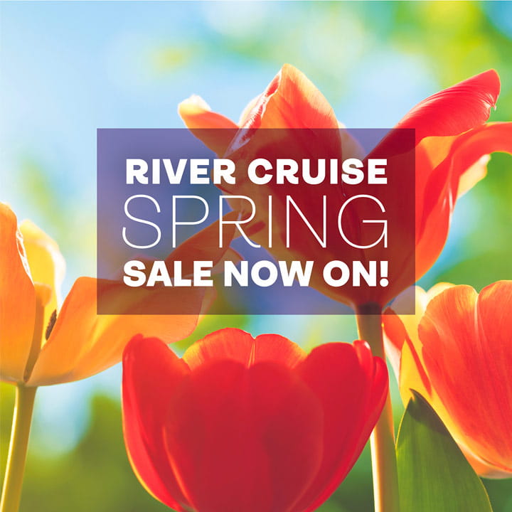 The words 'River cruise spring sale now on!' in a translucent black box overlaid on a close up image of tulips on a sunny day